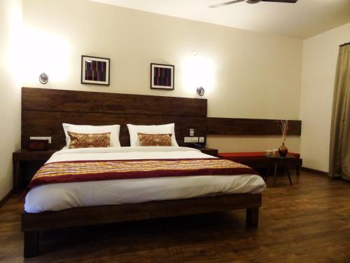 a bedroom with a large bed with a wooden headboard at Utse Suites in Bengaluru
