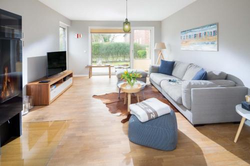 a living room with a couch and a tv at Mühlenloft in Norderney