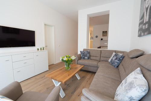 a living room with a couch and a tv at Meergenuss in Norderney