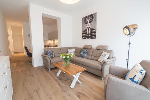 a living room with a couch and a table at Meergenuss in Norderney