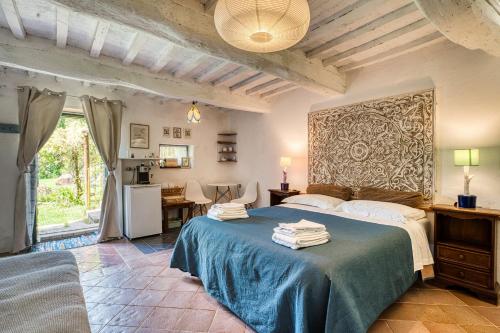 a bedroom with a bed with a blue blanket at Assisi Countryhouse in Assisi