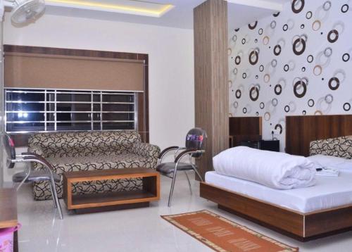 a bedroom with a bed and a couch and a chair at Hotel Rama palace in Mathura