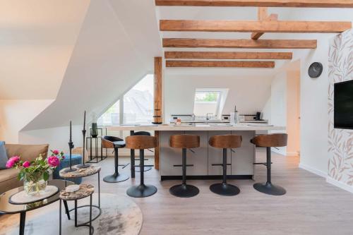 a kitchen and living room with a counter and stools at Neywatt 1 in Norderney