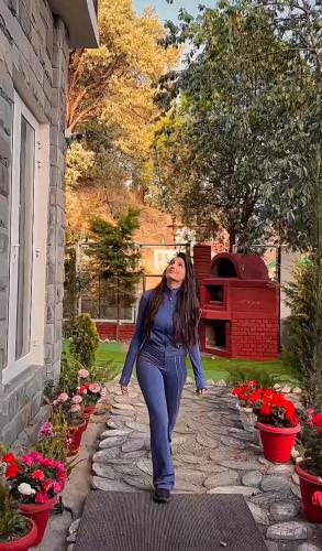 a woman is standing on a stone walkway at Casa De Bello, Nainital, Near Kainchi Dham in Bhowāli