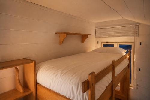 a bed in a small room with a window at Chalet in de Ardennen Comfort & Stilte The Wood in Amblève