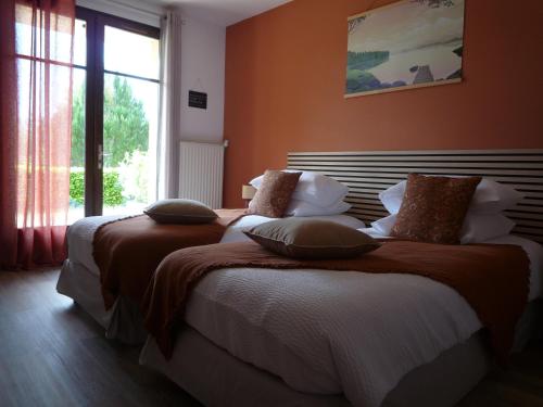 two beds sitting in a room with a window at Maison du Pech in Carlux