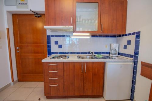 a kitchen with wooden cabinets and a sink at La porta sul Mare - Apartment Punta in Veli Lošinj