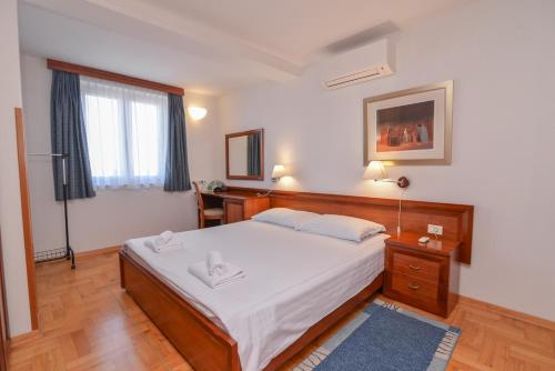 a bedroom with a bed and a window at La porta sul Mare - Apartment Punta in Veli Lošinj