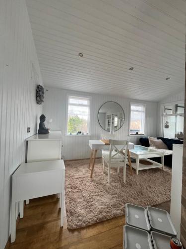 a living room with white furniture and a table at Cozy Cabin Iceland in Reynivellir