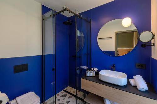 a blue bathroom with a sink and a mirror at Luna Residence in Timişoara