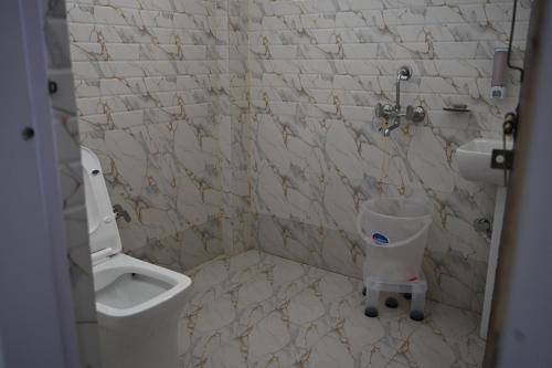 a bathroom with a toilet and a sink at Hotel Uday Villa in Kharsālī