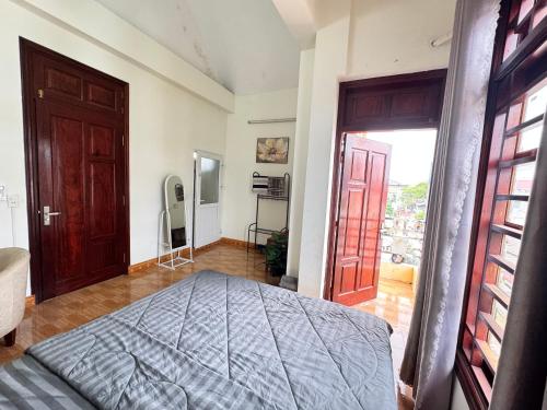 a bedroom with a bed and a door to a balcony at Hava Hostel Lang Son in Lạng Sơn