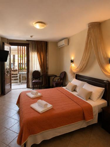 ein Schlafzimmer mit einem großen Bett, auf dem zwei Handtücher liegen in der Unterkunft Giannis & Foteini in Afytos