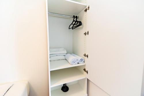 a small closet with white shelves and towels at Dzon Beachside Apartments in Vinišće