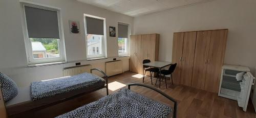 a room with two beds and a desk and windows at Ferienwohnung in Georgenthal in Georgenthal