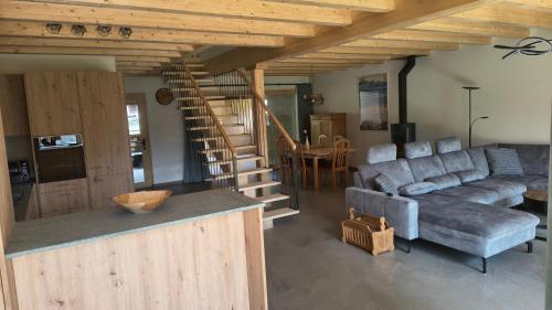 a living room with a couch and a staircase at Ferienwohnung - schof in Tschierv