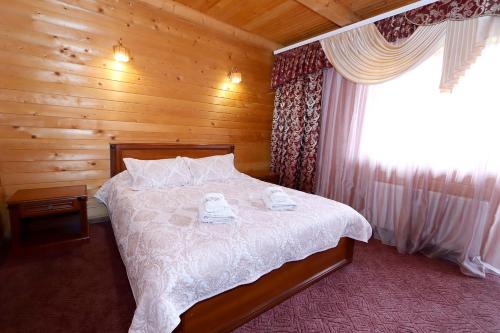a bedroom with a bed in a wooden cabin at Садиба "Едем" in Mykulychyn
