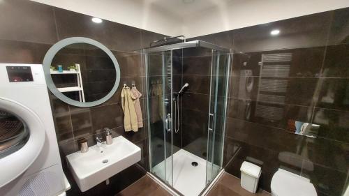 a bathroom with a shower and a sink and a mirror at Apartment Moser 1303 in Karlovy Vary