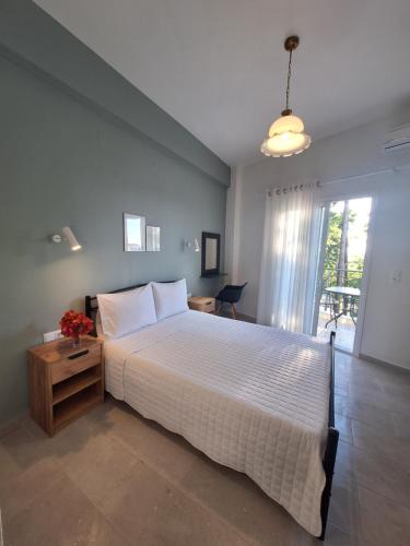 ein Schlafzimmer mit einem großen weißen Bett und einem Fenster in der Unterkunft Manis Central Studios in Skala Sotiros