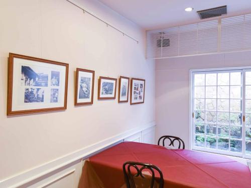 a dining room with a red table and a window at Hotel Hagoromo in Shizuoka