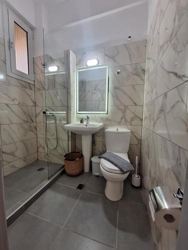 ein Badezimmer mit Toilette, Waschbecken und Dusche in der Unterkunft Manis Central Studios in Skala Sotiros