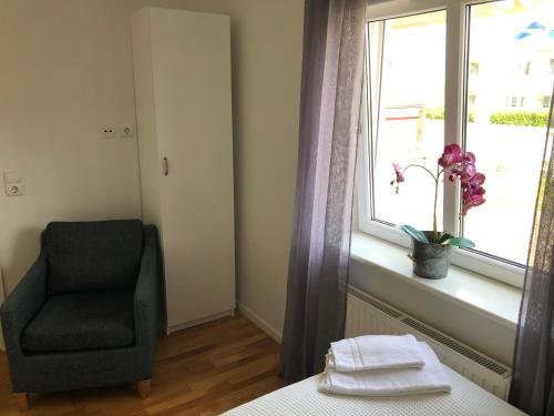 a bedroom with a chair and a window at Mysiga Villan in Borgholm