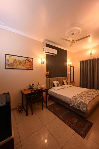 a bedroom with a bed and a desk in a room at Ardas Villa Bikaner - Heritage Luxury Boutique Stay, With Free Pick Up and Drop in Bikaner
