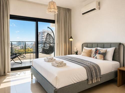 a bedroom with a large bed and a balcony at Caesar Resort & Spa Collection Studios Pools & Long Beach in Iskele