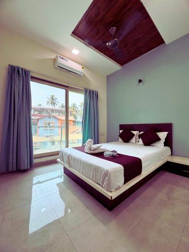 a bedroom with a large bed and a large window at Fortune Resort in Alībāg