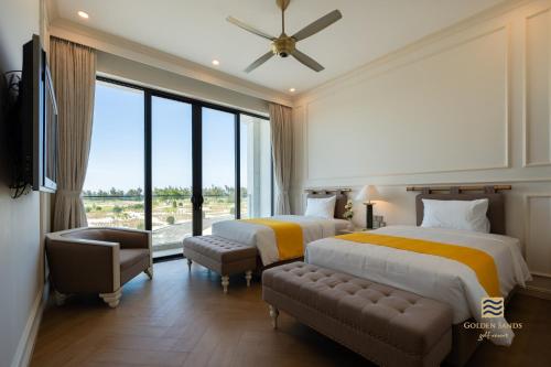 two beds in a hotel room with a large window at Golden Sands Golf Resort in Hue
