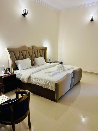 a bedroom with a large bed and a table at Corbett Sun Shine in Rāmnagar