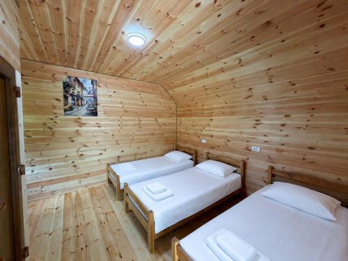 a room with two beds in a wooden cabin at Nature Guesthouse Vuthaj in Vusanje