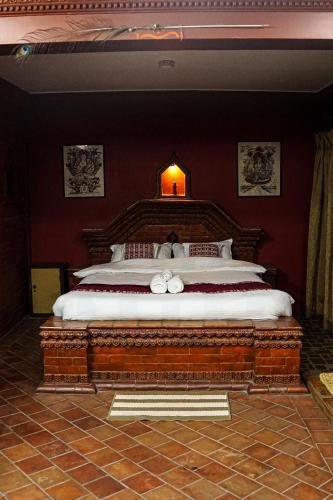 a bedroom with a large bed in a red wall at Hotel Terracotta in Bhaktapur