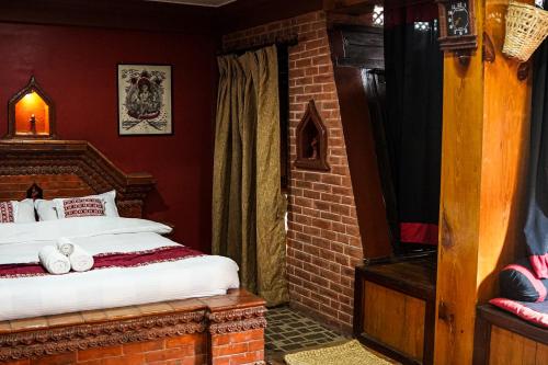 a bedroom with a bed in a brick room at Hotel Terracotta in Bhaktapur