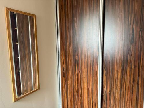 a wooden door with a mirror on a wall at 11 smart by LibertaRent in Wałbrzych
