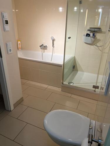 a bathroom with a shower and a toilet and a tub at Das Gäste Haus in Dresden