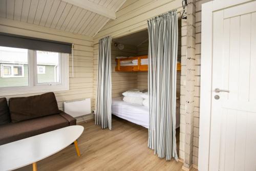 ein Zimmer mit einer Couch, einem Bett und einem Fenster in der Unterkunft Móar Cottage in Akranes