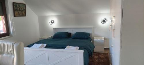 a bedroom with a bed with a green comforter at Honey House Martinovic in Cetinje