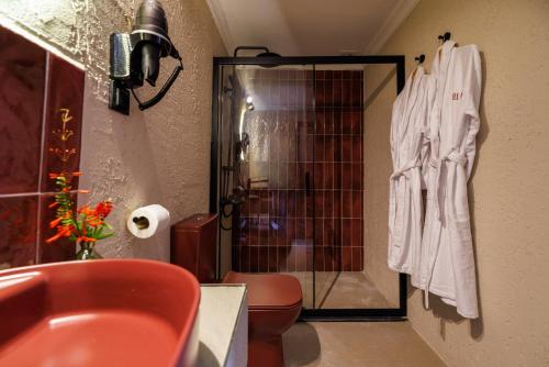 a bathroom with a toilet and a glass shower stall at Lill Maison Hotel & City Club in Fethiye