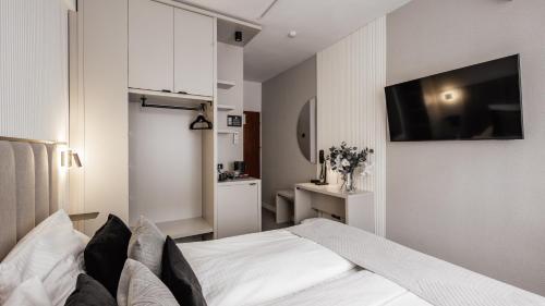 a bedroom with a bed and a tv on the wall at Hotel Delta in Krakow
