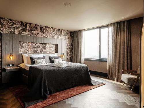 a bedroom with a large bed and a large window at Van der Valk Hotel Dordrecht in Dordrecht