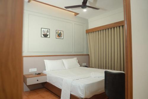 a bedroom with a bed and a ceiling fan at Arma Residency Kannur in Kannur