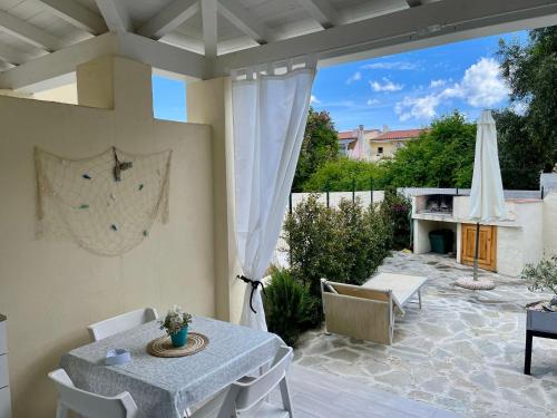 a patio with a table and chairs and an umbrella at FeMar in Porto Ottiolu