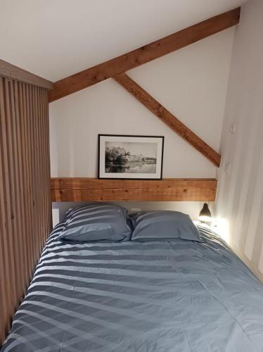 a bedroom with a large bed with a wooden headboard at Maison centre-ville, Vue château, Hellfest, Clisson in Clisson