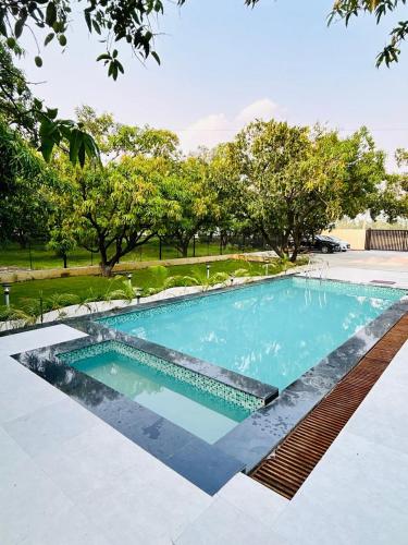 a swimming pool in a yard with trees in the background at Corbett Sun Shine in Rāmnagar