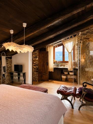 a bedroom with a bed and a desk in a room at Complejo Rural Lar de Vies in A Pontenova