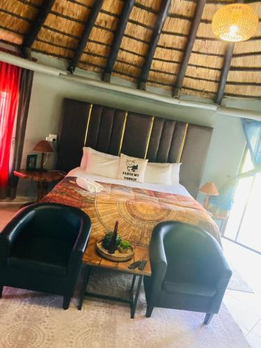 a bedroom with a bed with a table and a chair at Munati B&B in Musina