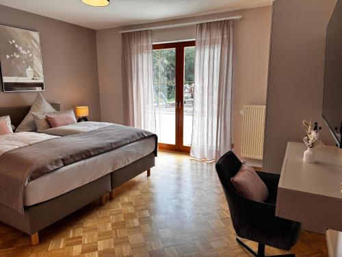a bedroom with a bed and a desk and a window at Ferienwohnungen Auszeit Taubertal in Bad Mergentheim