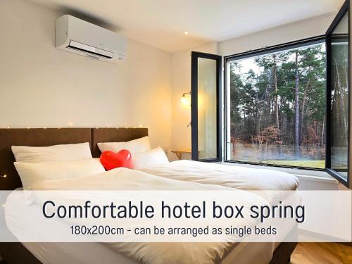 a hotel room with a bed and a large window at Baham-Apartment Nuernberg - including hot tub, sauna, massage chair, roof terrace, barbecue - metro 15 min, exhibition center 8 min walk in Nuremberg