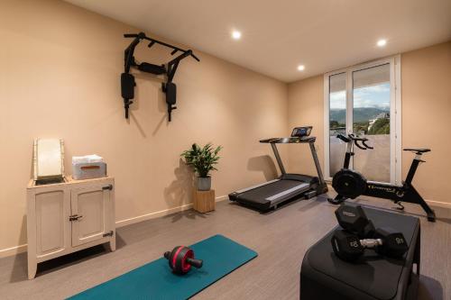 a living room with a treadmill and a gym at Kyriad Chambéry Centre - Hôtel et Résidence in Chambéry